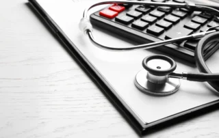 Stethoscope and calculator on a medical report representing medical debt and bankruptcy in Michigan